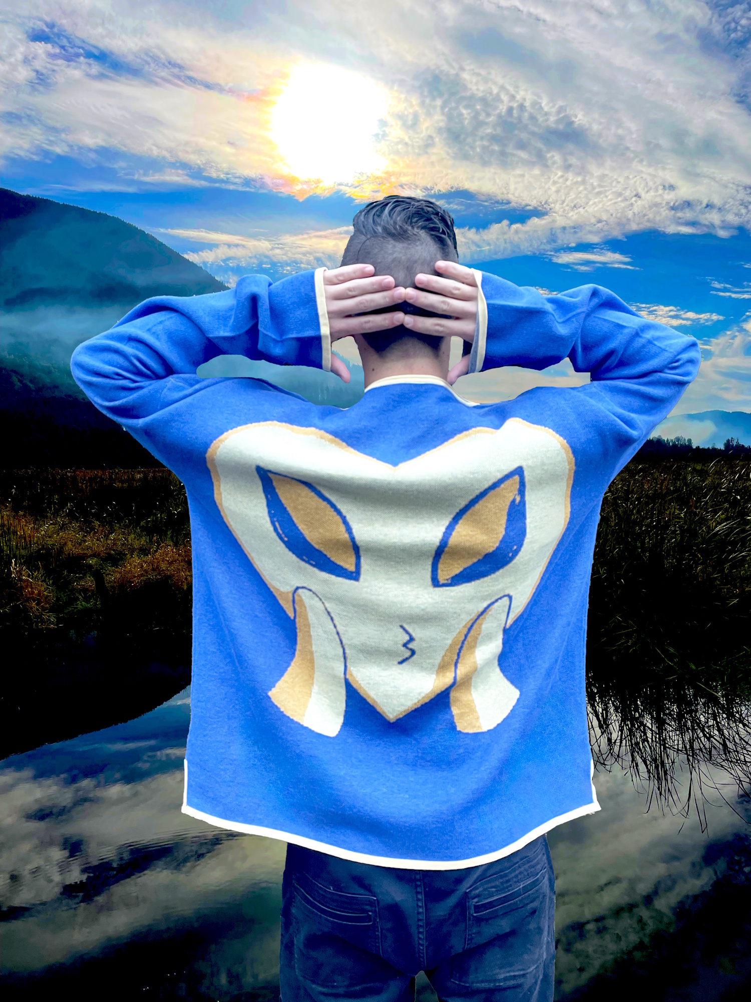Model shows the back of sweater which is a replica image of the yellow heart, with alien eyes, blowing the viewer a kiss.