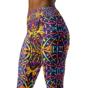 Model wears BoomBoom Yoga pants with baseball cap and black blouse. Model stands out against the mountain backdrop with the BoomBoom yoga leggings striking bold colourful patterns.