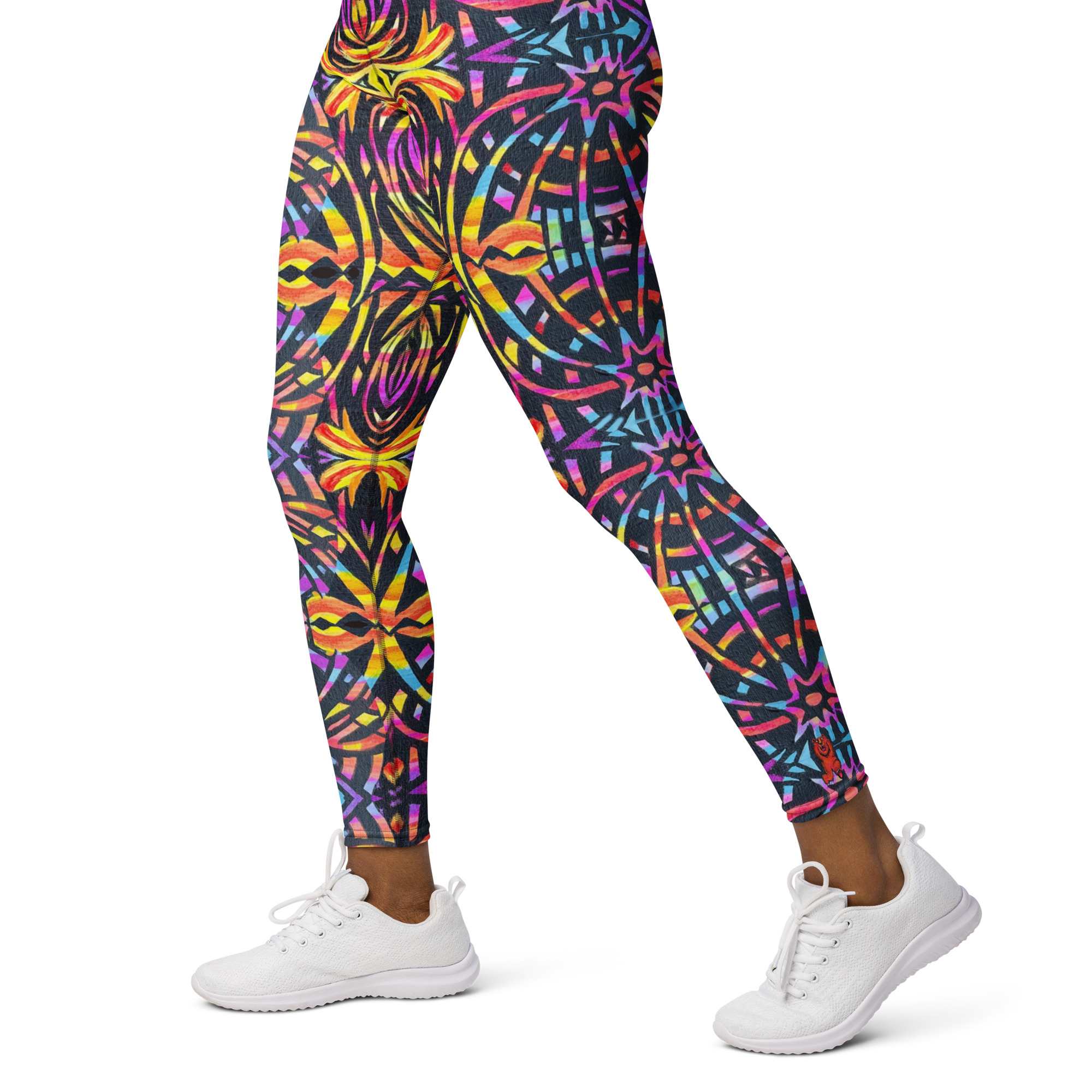Model wears BoomBoom Yoga pants with baseball cap and black blouse. Model stands out against the mountain backdrop with the BoomBoom yoga leggings striking bold colourful patterns.