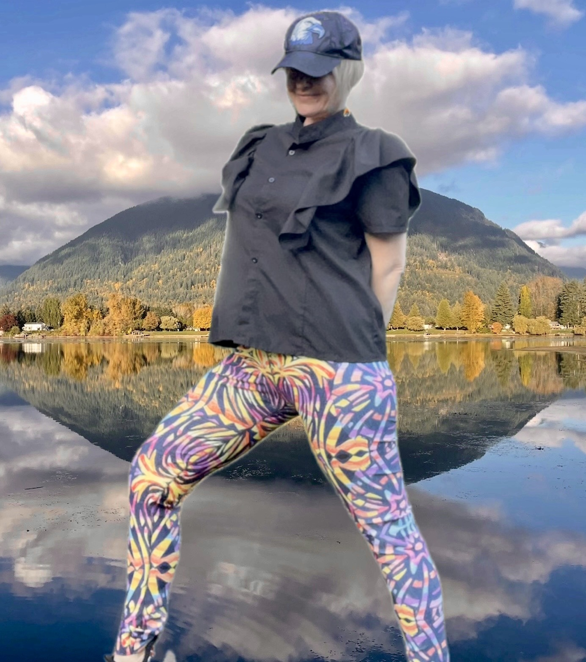 Model wears BoomBoom Yoga pants with baseball cap and black blouse. Model stands out against the mountain backdrop with the BoomBoom yoga leggings striking bold colourful patterns.