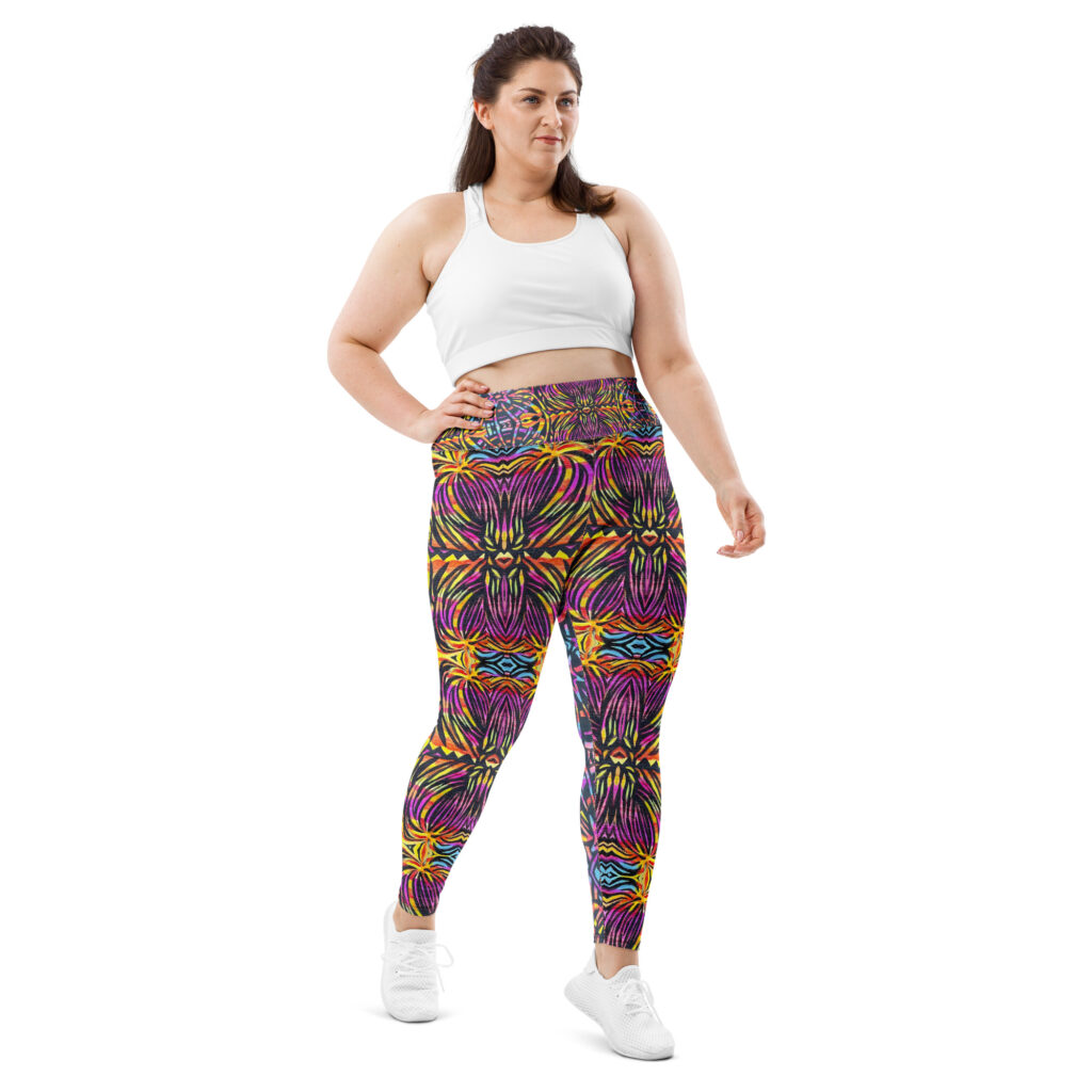 Plus-size model wearing kaleidoscopic patterned leggings in purple, yellow, orange, and blue with crop top. Inspired by fireworks and artwork from the Scared BEar Art & Inquiry Book.