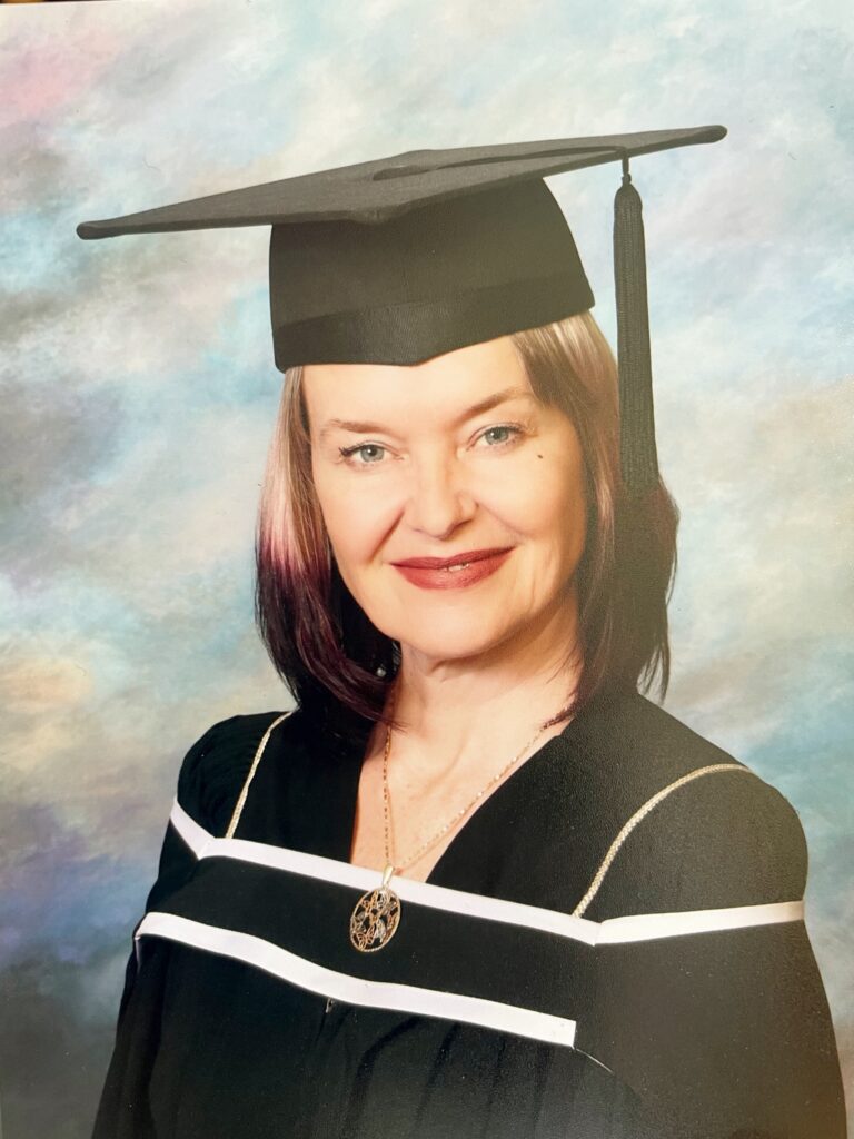 Tanya Tee Coghill poses in Graduation cap and gown.