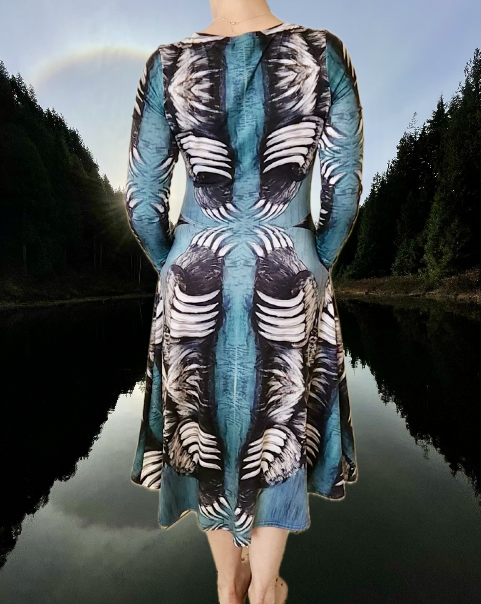 Back view of dress shows bear claws almost touching at the spine. Teal midi dress with mirrored bear‑claw pattern in white, grey, and black With pockets. Model wears size S.