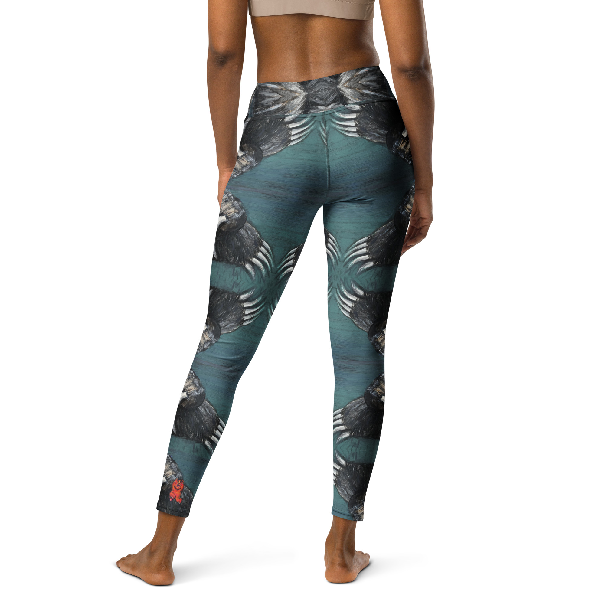 A woman in high waist with a wide waist band yoga leggings. White and black bear claws on a deep green background create a mirror pattern with 360 degrees of fashion designed by Tanya Tee Art_TLC.