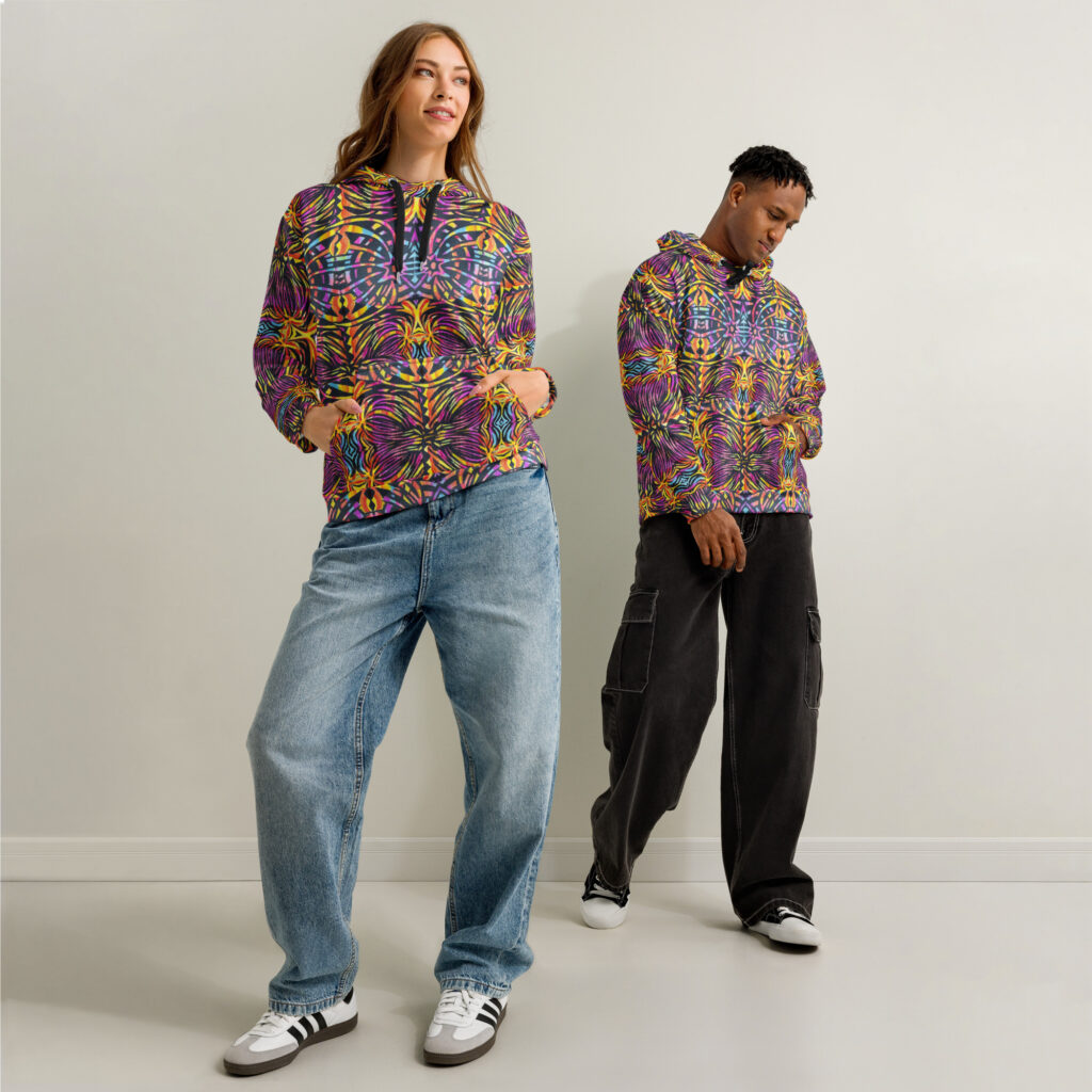 Two models, one male, one female, both wear a BoomBoom Cotton Hoodie against white wall. An explosion of colour and a pattern that invites adventure.