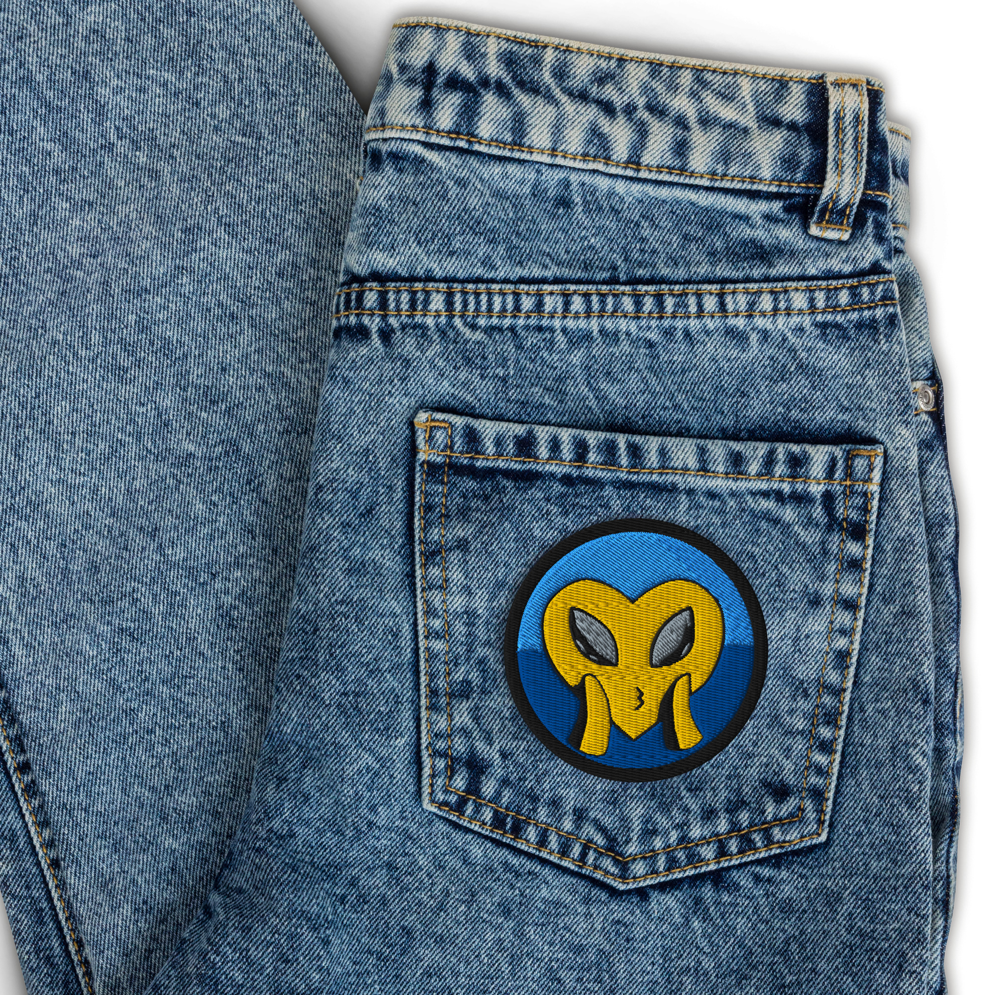 Model wears Alien Love Patch on a pair of jeans. The yellow heart face blowing a kiss with cute loving alien eyes reminds us Love is Universal. This unique patch is designed by Tanya Tee Art_TLC from her original artworks making it a small but powerful wearable art work.
